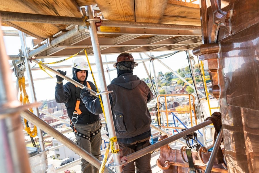 the durable slate employees discussing historic preservation work on scaffold