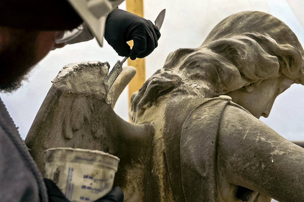 restoring a cemetery monument by hand with applied mortar